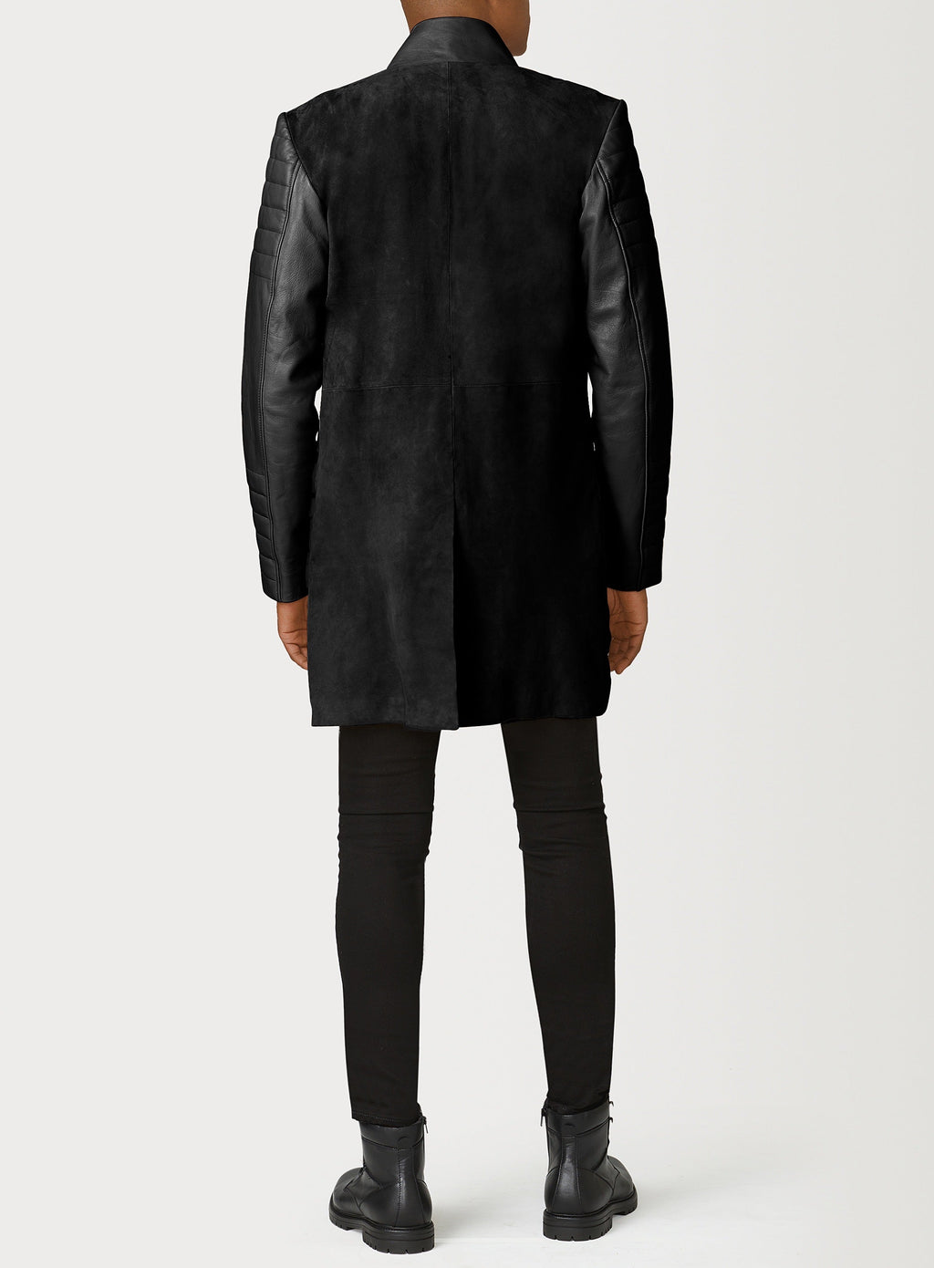 A Beautiful Black Suede Trench Coat, created by designer brand PRSVR. The PRSVR Lab Coat has a suede Body, and lambskin leather sleeves that show off a padded ribbed design on the shoulder and wrist of the sleeve. 