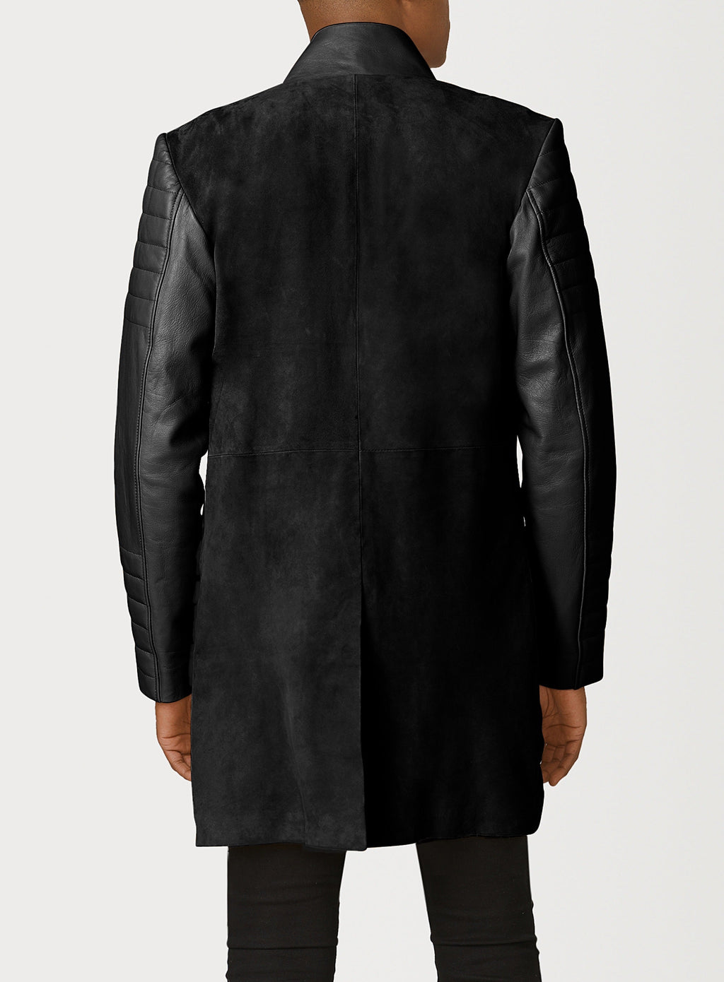 A Beautiful Black Suede Trench Coat, created by designer brand PRSVR. The PRSVR Lab Coat has a suede Body, and lambskin leather sleeves that show off a padded ribbed design on the shoulder and wrist of the sleeve. 