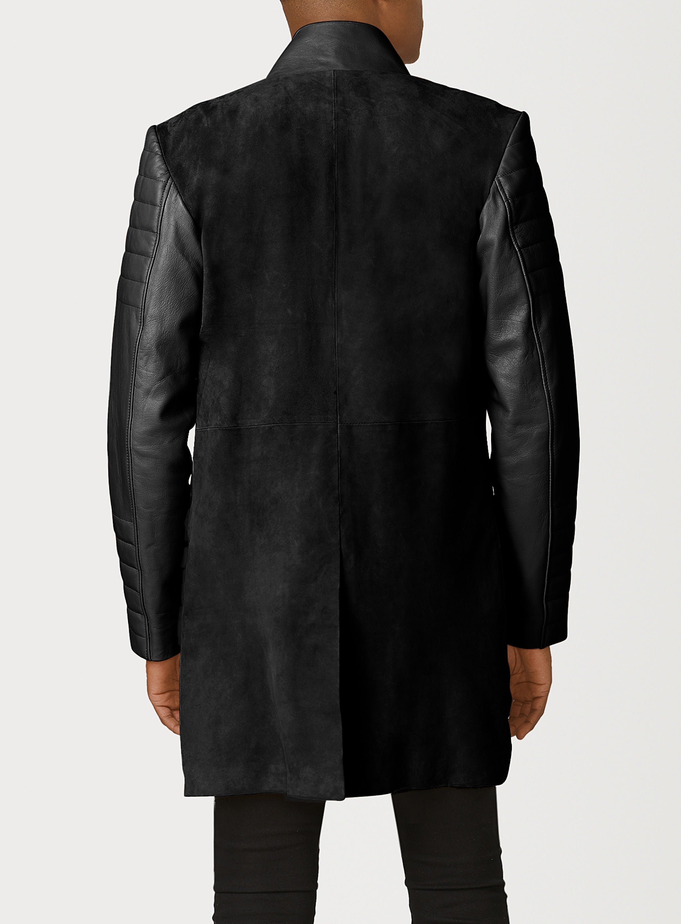 A Beautiful Black Suede Trench Coat, created by designer brand PRSVR. The PRSVR Lab Coat has a suede Body, and lambskin leather sleeves that show off a padded ribbed design on the shoulder and wrist of the sleeve. 
