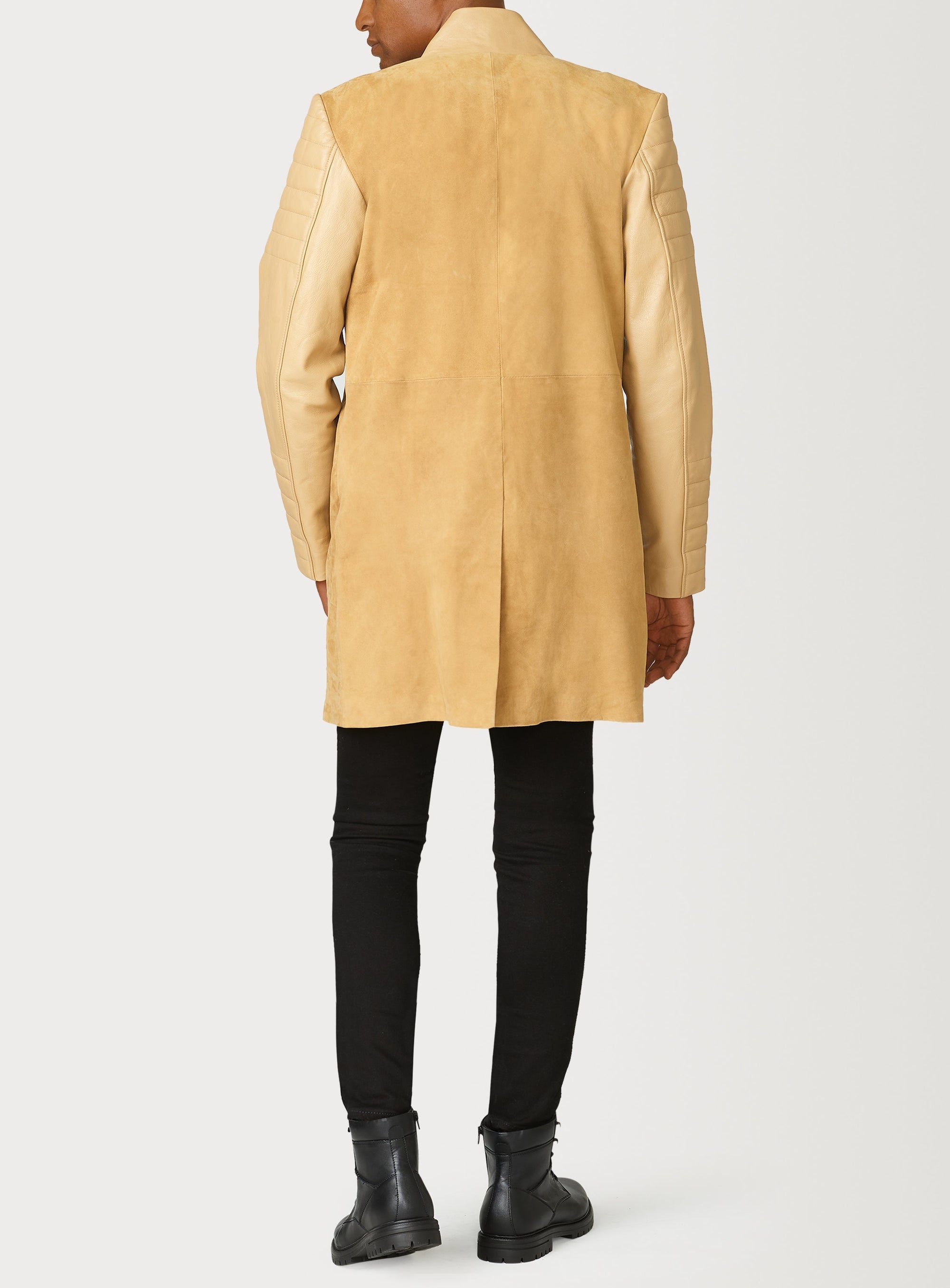 A Beautiful Suede Trench Coat, created by designer brand PRSVR. The PRSVR Lab Coat has a suede Body, and lambskin leather sleeves that show off a padded ribbed design on the shoulder and wrist of the sleeve. 