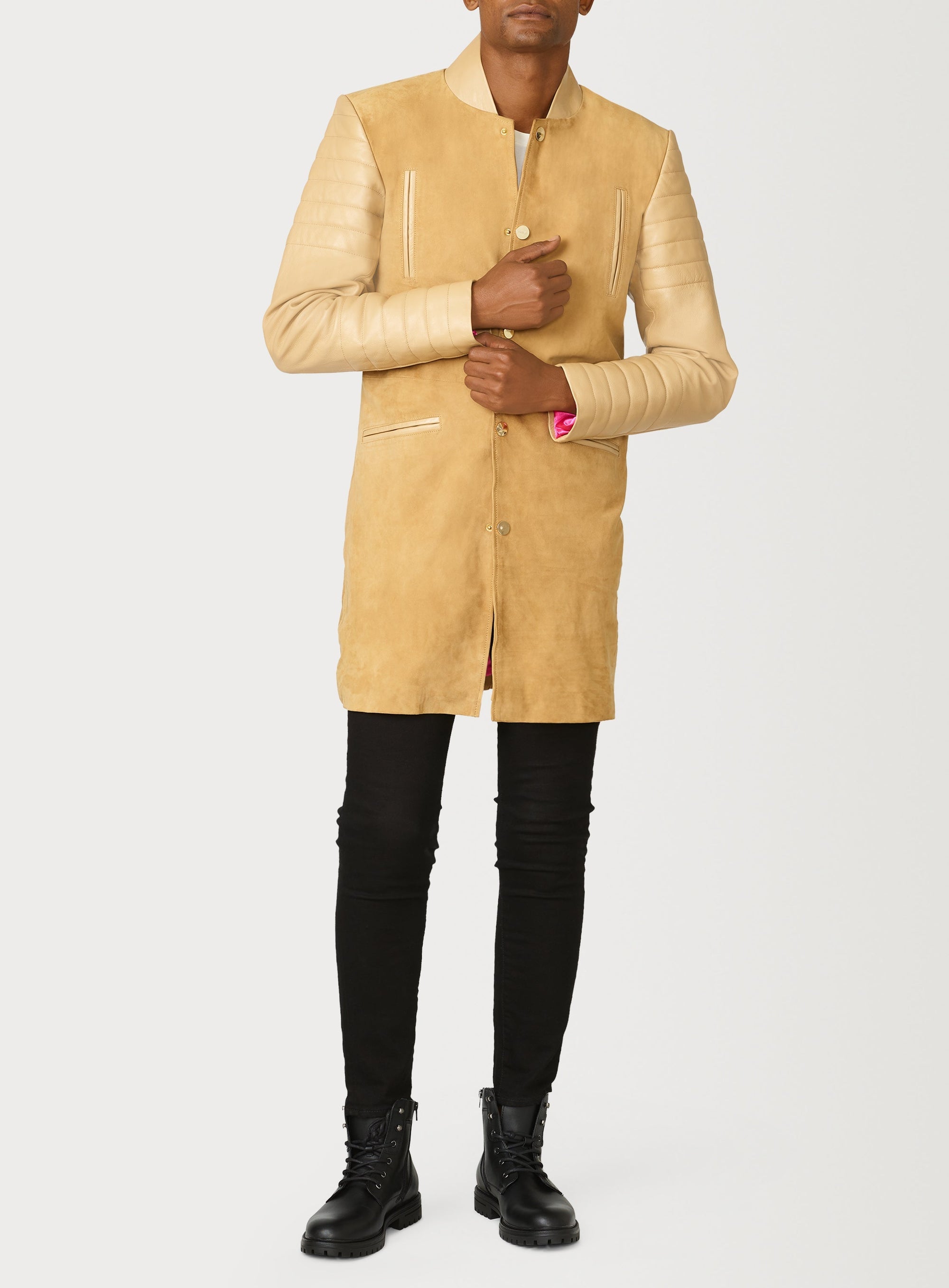 A Beautiful Suede Trench Coat, created by designer brand PRSVR. The PRSVR Lab Coat has a suede Body, and lambskin leather sleeves that show off a padded ribbed design on the shoulder and wrist of the sleeve. 