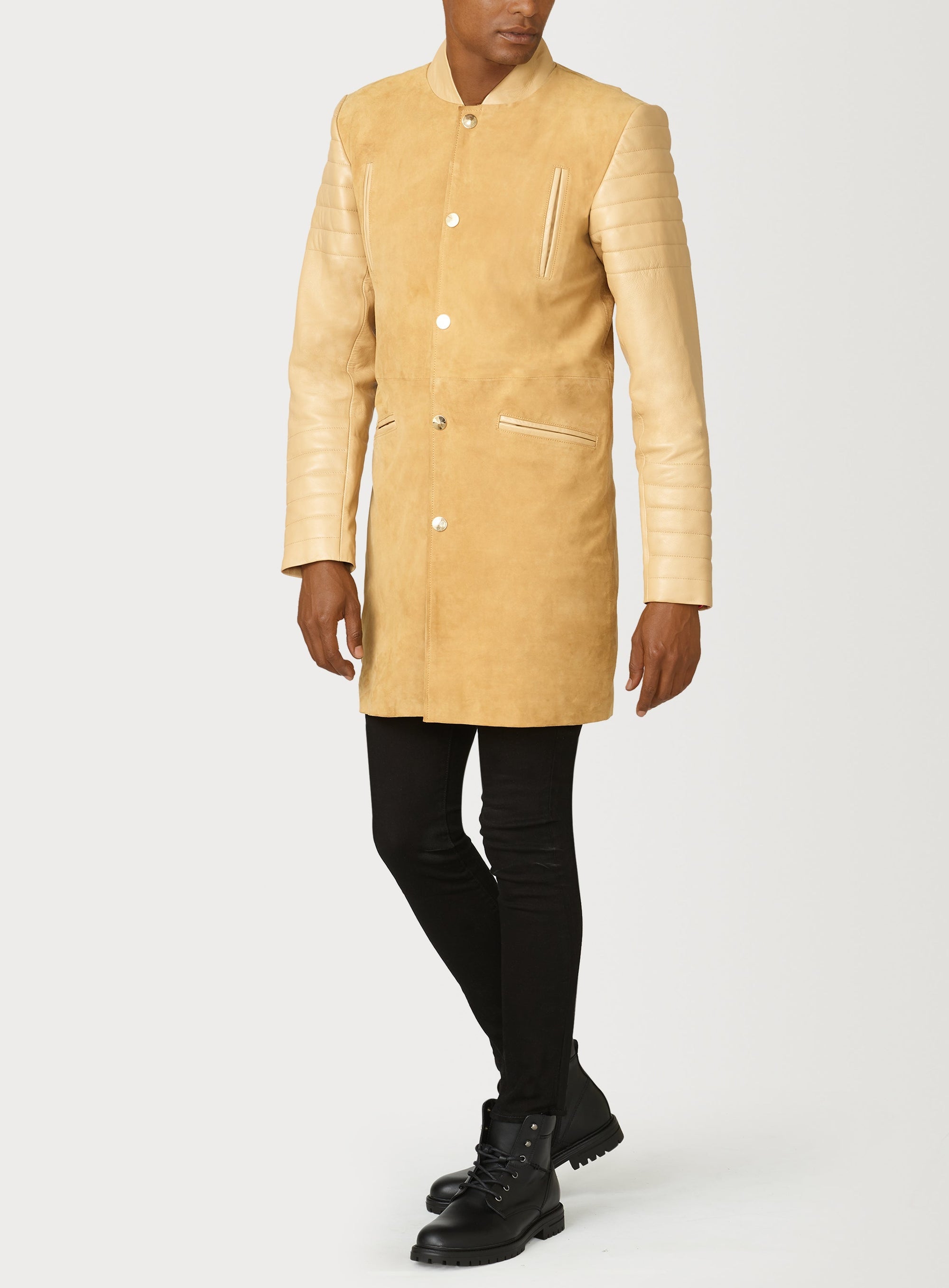 A Beautiful Suede Trench Coat, created by designer brand PRSVR. The PRSVR Lab Coat has a suede Body, and lambskin leather sleeves that show off a padded ribbed design on the shoulder and wrist of the sleeve. 